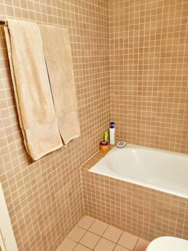 La salle de bains est pourvue d'une baignoire et d'une serviette. dans l'établissement Espacioso apartamento, à Genève