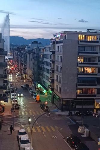 una calle de la ciudad con coches y edificios por la noche en Espacioso apartamento en Ginebra