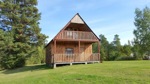 a large wooden cabin in a grassy field at Priedīši in Aglona