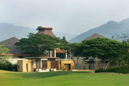 a large house with trees in front of it at Kirimaya Golf Resort Spa - SHA Plus Certified in Mu Si