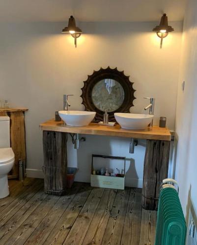 - une salle de bains avec deux lavabos sur un comptoir en bois dans l'établissement Original and quirky village home, à Giat