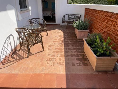 een patio met een tafel, stoelen en planten bij Sunny Room in a cozy Villa in Sperlonga