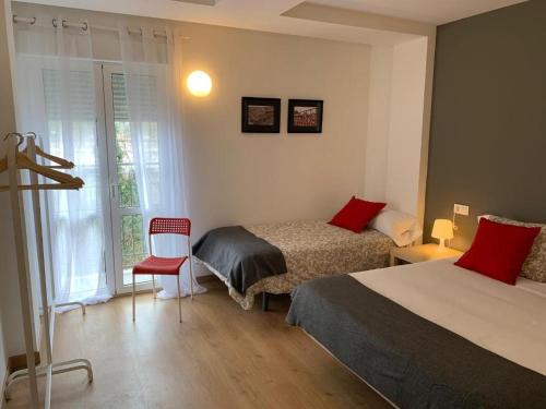- une chambre avec deux lits, une chaise et une fenêtre dans l'établissement Apartamento Labegain 3, à Sestao