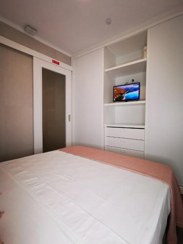a bedroom with a bed and a tv on a wall at Apartamento ms in Campo Maior