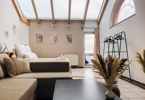 uma sala de estar com um sofá e uma mesa em Stadtoase Fulda mit flair - Whirlpool, Balkon, 2xParkplätze, Highspeed WLAN em Fulda
