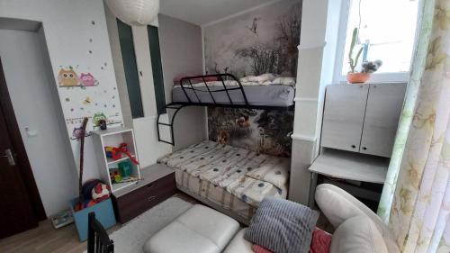 a small room with a bunk bed and a couch at Apartament Kimi&Maxi in Varna City
