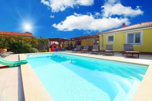 a swimming pool in front of a house at Ferienhaus mit Privatpool für 8 Personen ca 130 qm in Loborika, Istrien Südküste von Istrien in Loborika