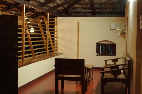 a room with two chairs and a table and a wine cellar at Greene Villa in Palakkad