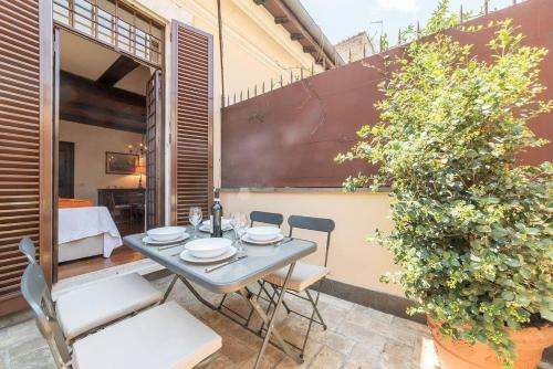 een patio met een tafel en stoelen en een plant bij Ferienwohnung für 6 Personen ca 90 qm in Rom Centro Storico, Latium Rom und Umgebung in Rome