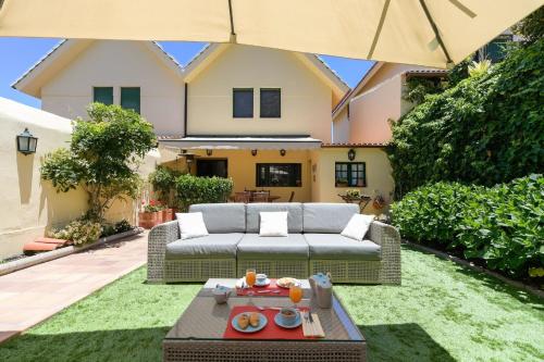 einen Hinterhof mit Sofa und Sonnenschirm in der Unterkunft Ferienhaus für 6 Personen ca 120 qm in Santa Brígida, Gran Canaria Binnenland Gran Canaria in Santa Brígida