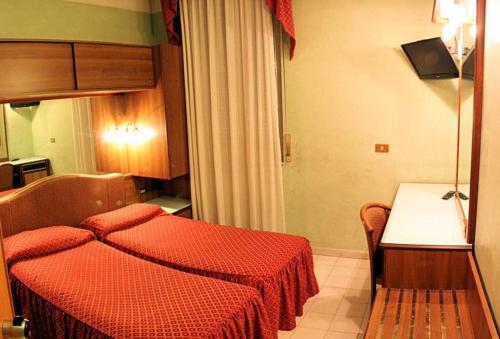 a bedroom with a red bed and a table at Hotel Vienna in Milan