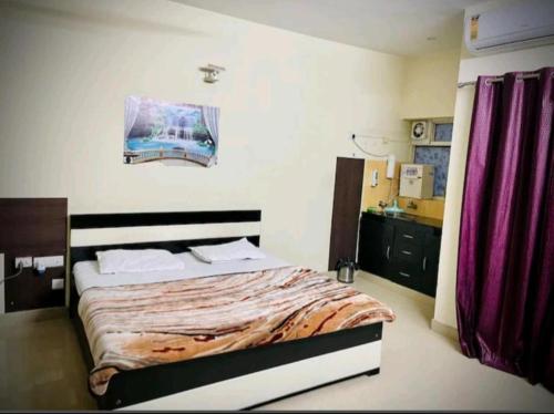 ブリンダーバンにあるAc Beautiful and Luxurious Stay Omaxe Jai Brij Biharijiのベッドルーム(ベッド1台、紫色のカーテン付)
