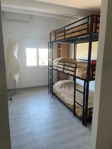 deux lits superposés dans une chambre avec fenêtre dans l'établissement Air-conditioned apartment beach access on foot, à Lumio