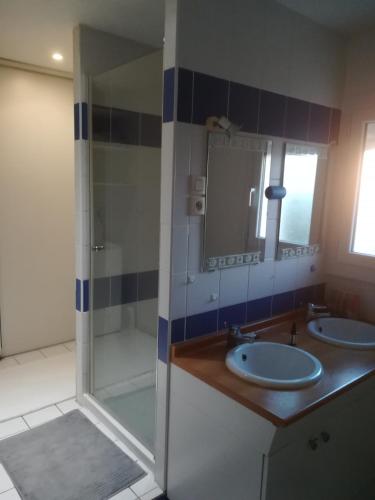 La salle de bains est pourvue de 2 lavabos et d'une douche avec un miroir. dans l'établissement maison T4, confort, bord de l'étang,10 mn du centre, avec jardin, à Sète