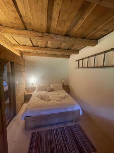 a bedroom with a bed with a wooden ceiling at La Baita di Aclete in Tarvisio