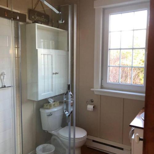 a bathroom with a toilet and a window at Beautiful oceanfront cottage in Guysborough