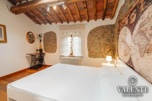 um quarto com uma cama branca e um mapa na parede em Casa con vista panoramica, Matraia, Lucca em Matraia