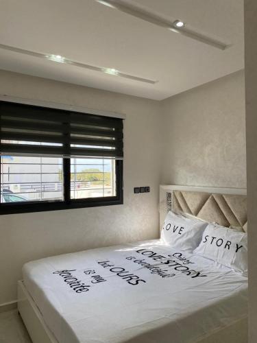 Mini villa Al hoceima في الحسيمة: غرفة نوم بسرير ابيض مع نافذة