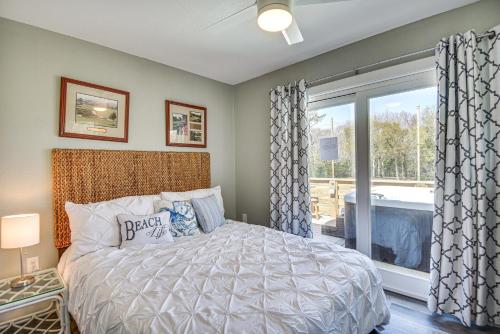Un dormitorio con una cama y una ventana grande. en Kitty Hawk Apartment with Hot Tub - 1 Mi to Beach!, en Kitty Hawk