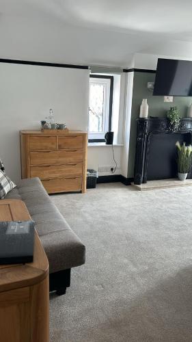 a living room with a couch and a dresser at The Fishmongers Tavern in Sheringham