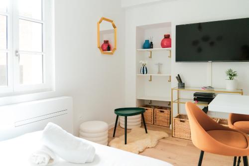 een woonkamer met een bureau en een televisie bij ô Quai St Pierre in Toulouse
