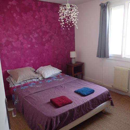 - une chambre avec un lit violet et 2 serviettes dans l'établissement maison T4, confort, bord de l'étang,10 mn du centre, avec jardin, à Sète