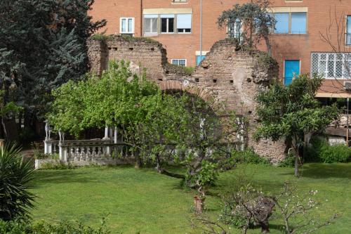 an old brick wall with a tree in a yard at Hotel Santa Maura in Rome