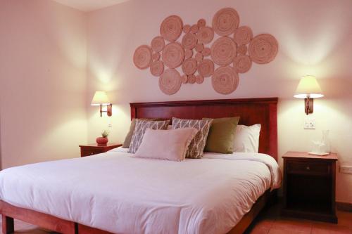 a bedroom with a large bed with white sheets and pillows at HOTEL COLLI in San José del Cabo