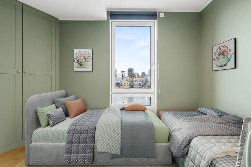 1 dormitorio con cama, sofá y ventana en Seafront Apartment at Sørengka OSLO, en Oslo