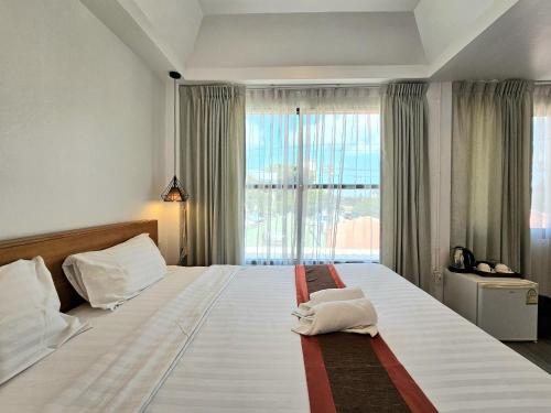 a bedroom with a large bed with a large window at 39 Living Pattaya in Pattaya Central