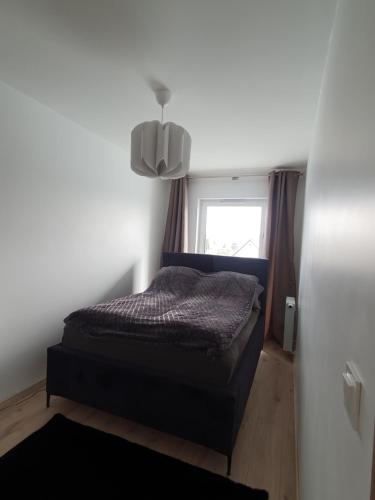 a small bedroom with a bed and a window at Apartament Number 2 NOVA WOZOWNIA Free Parking in Leszno