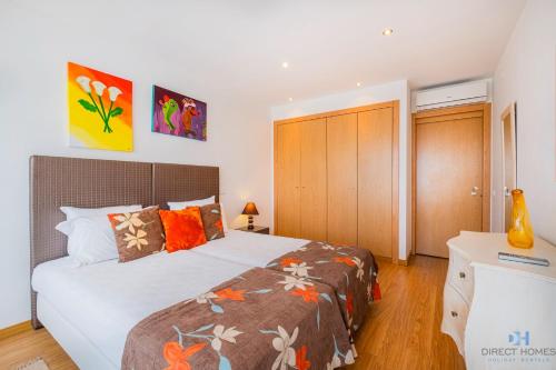 a bedroom with a large bed with orange pillows at Villas Rocha in Albufeira