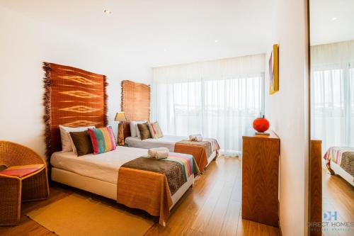 a bedroom with two beds and a window at Villas Rocha in Albufeira