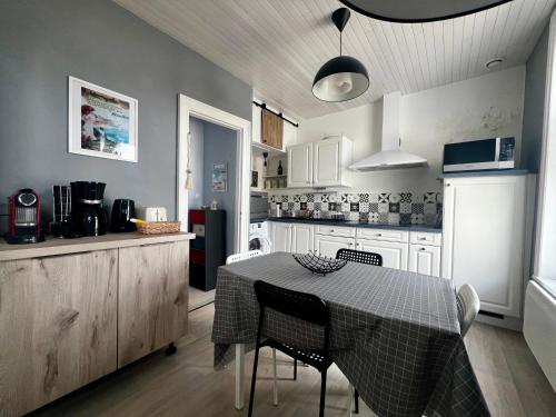 une cuisine avec une table et des chaises et une cuisine avec un comptoir dans l'établissement Le Santaline, à Wimereux