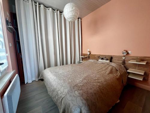 une chambre avec un lit et une grande fenêtre dans l'établissement Le Santaline, à Wimereux