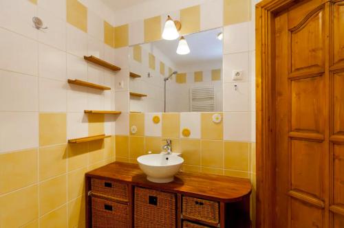 a bathroom with a sink and a mirror at Bíbor Apartment in Budapest