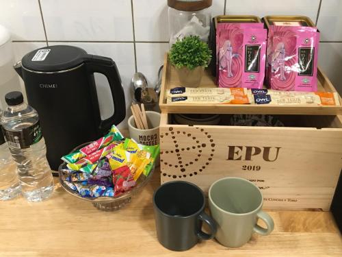 a table with two cups and a box of candy at Liuqiu Cozy Room in Xiaoliuqiu