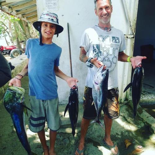 a man and a boy holding fish in their hands at Casa’ Mapola : typical beach jungle house in Pavones