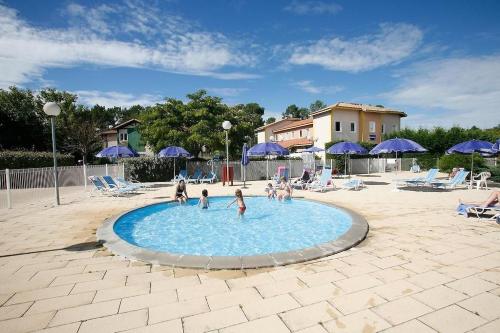 un groupe de personnes jouant dans une piscine dans l'établissement Jolie maisonnette dans village vacances Soustons plage, à Soustons