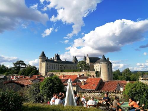 people sitting on roofs in front of a castle at Le Verger du Paradis in Beaulieu-sur-Sonnette