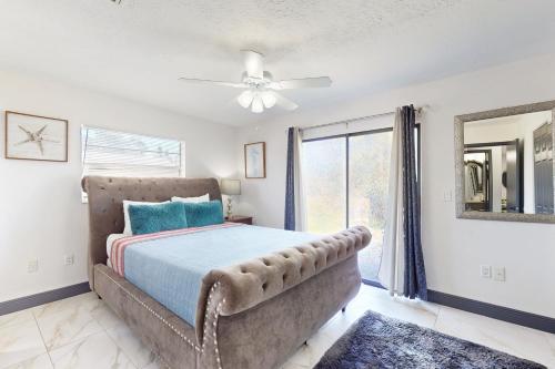 - une chambre avec un lit, un ventilateur de plafond et une fenêtre dans l'établissement BeachyChic Retreat 1, à Bradenton