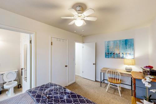 a bedroom with a bed and a desk and a ceiling fan at Midtown Hideaway in Coeur d'Alene