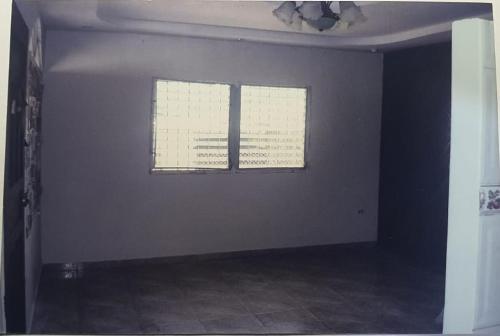 Betohouse في San Miguelito: غرفة فارغة مع نافذتين في منزل