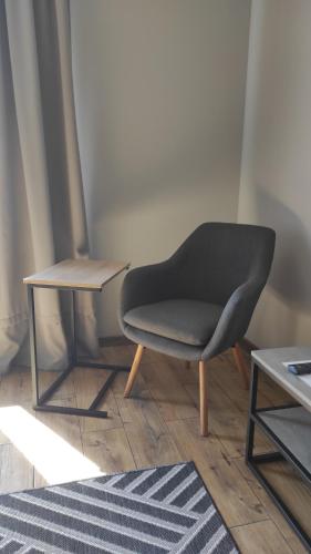einen Stuhl und einen Beistelltisch in einem Zimmer in der Unterkunft Нові Loft Апартаменти 5 (центр-залізничний вокзал) in Iwano-Frankiwsk