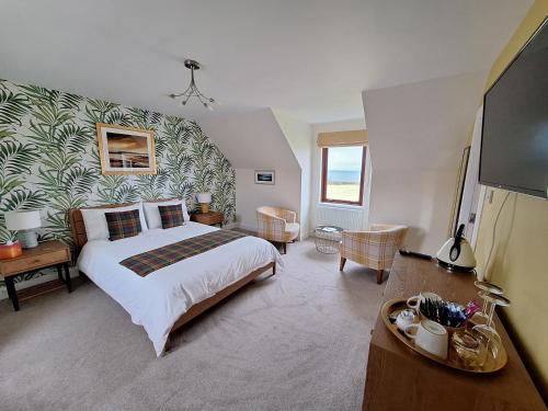 a bedroom with a large bed and a television at Lochview Guesthouse in Corran