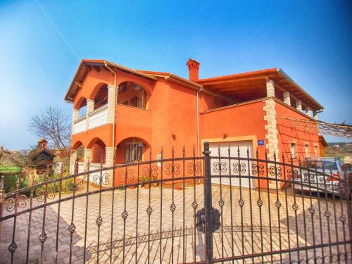 een oranje huis met een hek ervoor bij Ferienwohnung für 5 Personen ca 70 qm in Pula, Istrien Istrische Riviera - b60851 in Pula