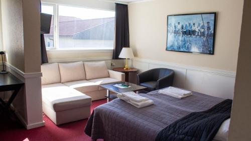 une chambre d'hôtel avec un lit et un canapé dans l'établissement A Hotels Roskilde, à Hedehusene