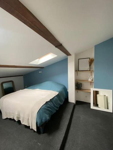 une chambre avec un lit et un mur bleu dans l'établissement Charmant moulin en pierre, à Saint-Pierre-de-Vassols