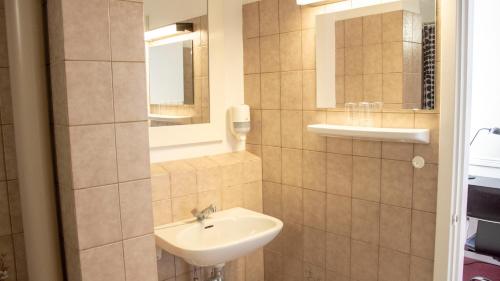 bagno con lavandino e specchio di A Hotels Roskilde a Hedehusene