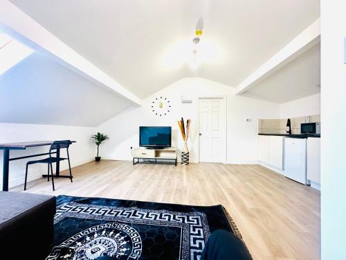 a white living room with a table and a tv at Albert Inn Apartments in Manchester